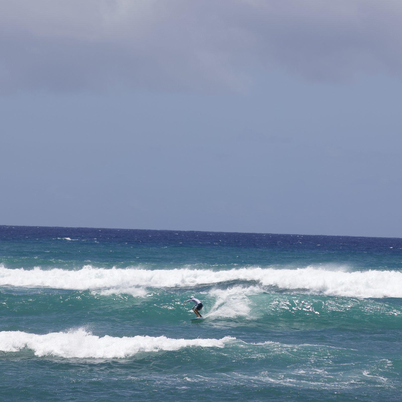 A surfer riding a wave off Diamond Head, O'ahu